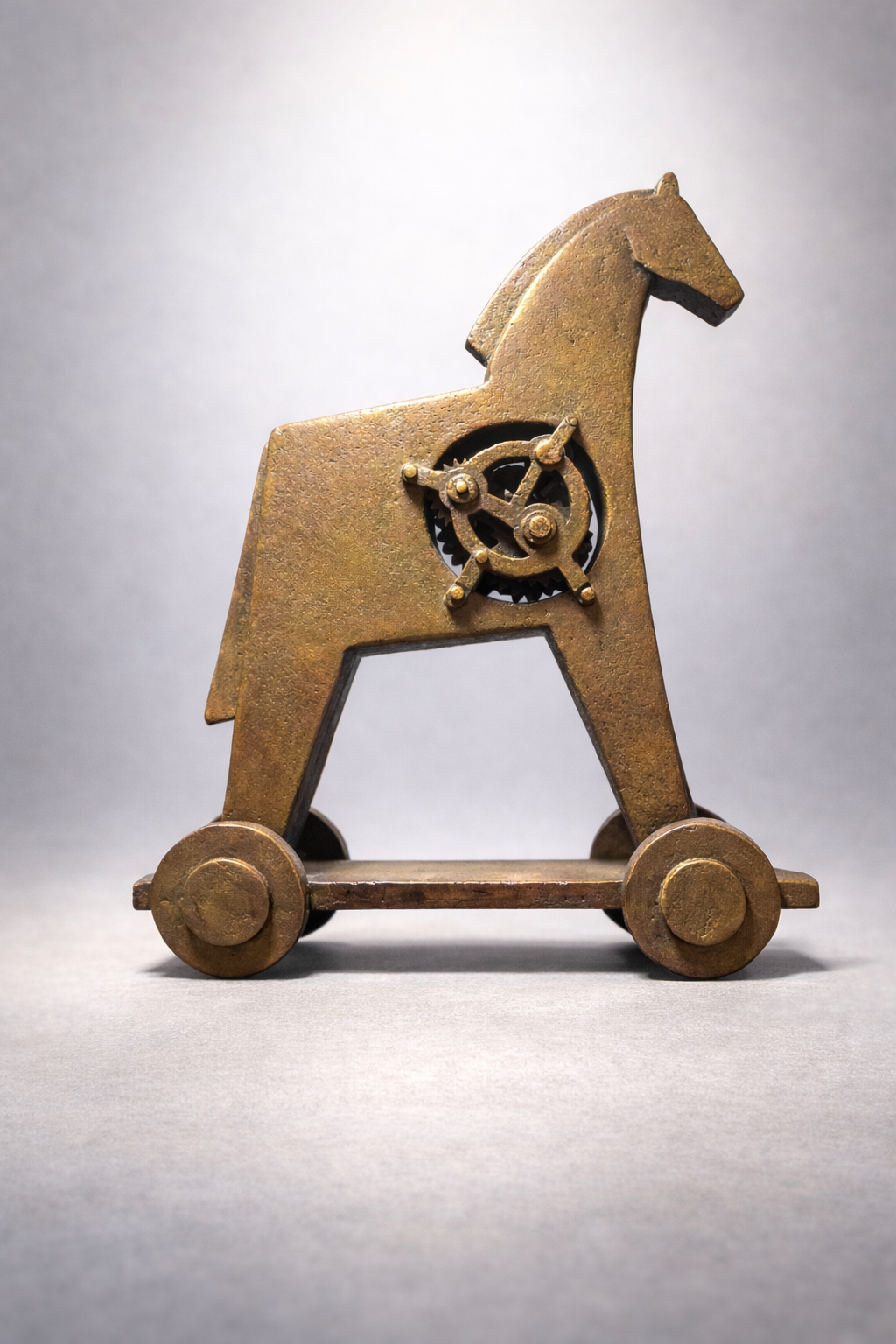 Bronzeskulptur eines stilisierten Pferdes auf Rädern mit sichtbarem Räderwerk