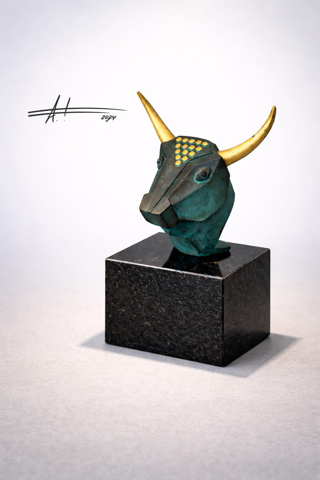 Bronzeskulptur eines abstrahierten Stierkopfs mit goldfarbenen Hörnern auf dunklem Sockel